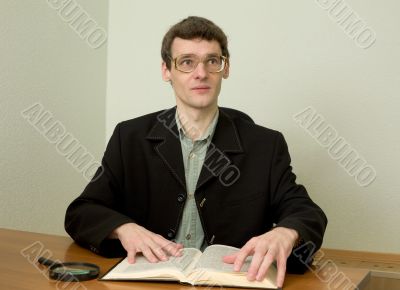 Guy in eyeglasses reads the book