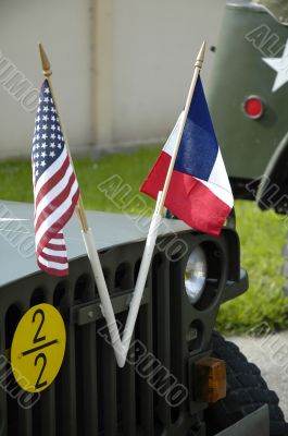 US and french flags front of an old jeep