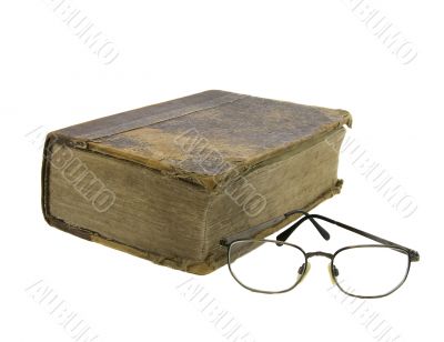 Glasses near very old bible on the white background
