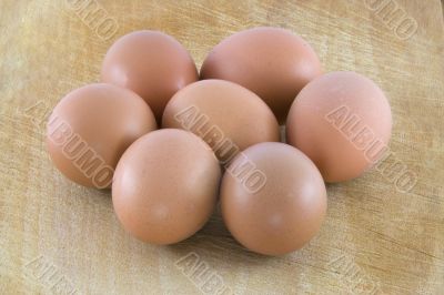 Many fresh rural eggs on the wooden surface