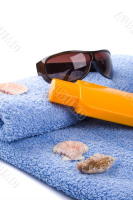 towel, shells, sunglasses and lotion