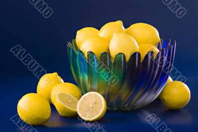lemons in blue green bowl on blue background