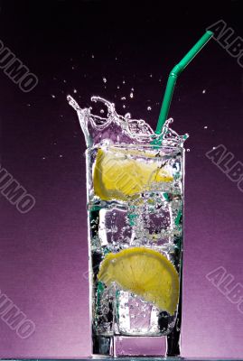 sliced lemon falling in glass of alcoholic drink