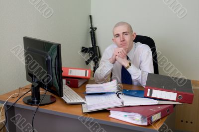 Chief on a workplace with a rifle on a background