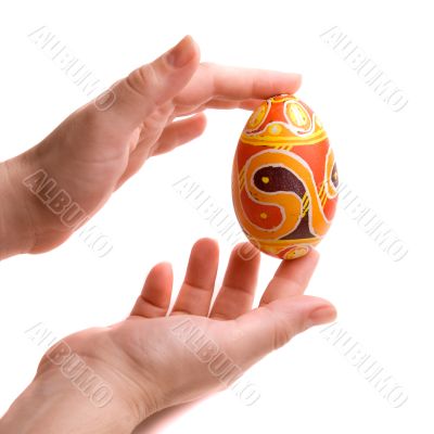 Hands with fingers folding Easter egg.