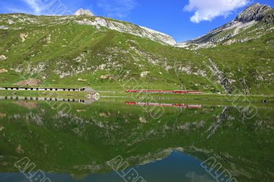 Train behind a lake with mountain and train