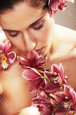 Beautiful young woman with orchid flowers