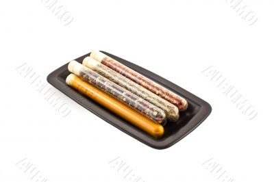 spices in a glass tubes on a black plate