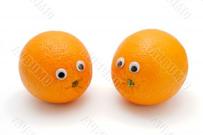 Two funny oranges with eyes on white