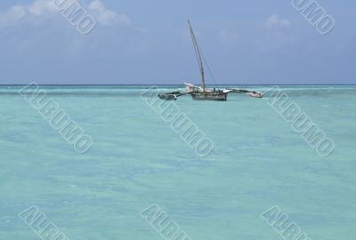 Old dhow in the crystal blue coastal waters of Zanzibar