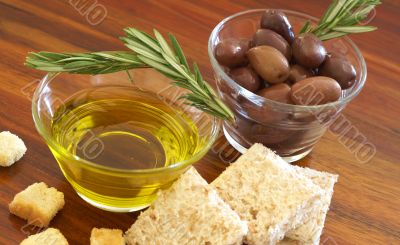 Two jars of black olives, oil and croutons