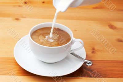 Closeup of milk being poured into the coffee
