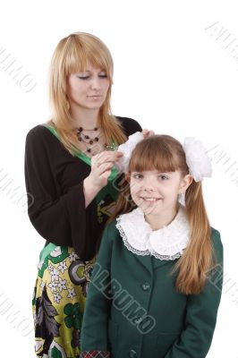 Mother is helping daughter prepare to school.