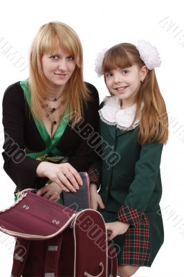 Mother is packing up backpack with daughter.
