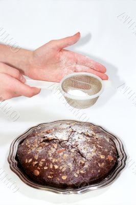 Chocolate cake and sieve in hands