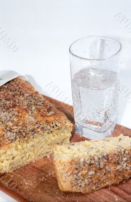 Cutting bread and glass of mineral water close up