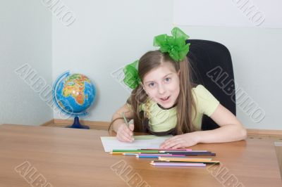 Girl sitting at a table with pencils