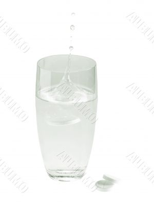 glass with water and aspirin pills