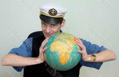 Man in a sea cap compresses globe in hands