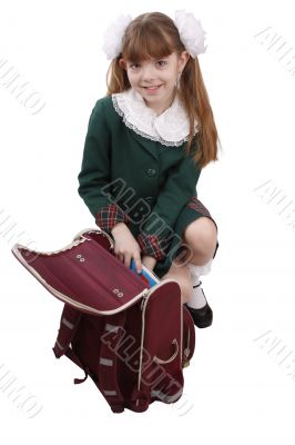 School girl is packing up backpack.