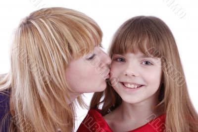 Mother is kissing her happy daughter.