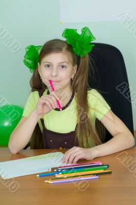 Girl sitting at a table with pencils