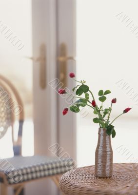 Flowers in the vase on the table near with window