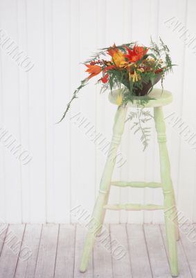 vase with the flowers on the white stool