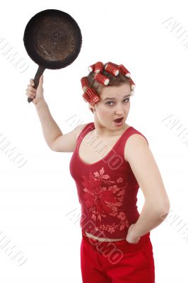Housewife with curlers is holding a frying pan.