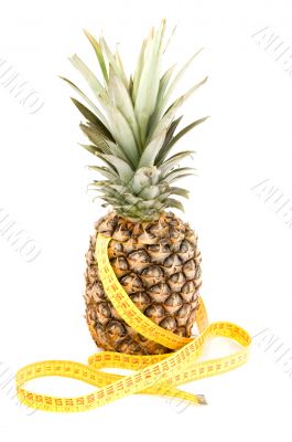 fresh pineapple with tape measure isolated on white background