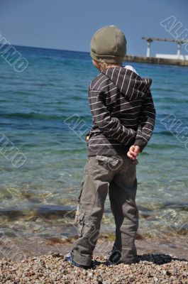 boy is looking at the sea