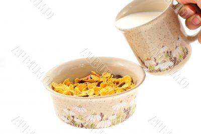 cornflakes and a hand with cup of milk