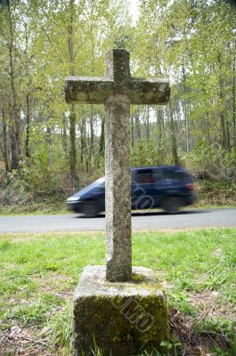 stone cross with car