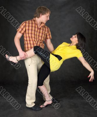 Couple dancing a tango on a black