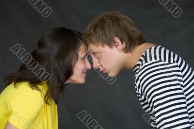Guy and the girl have faced foreheads on a black