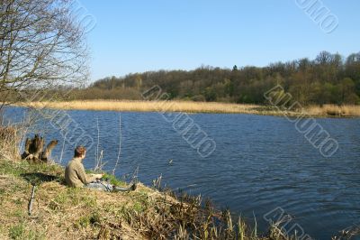 Fisherman sitting on the river shore