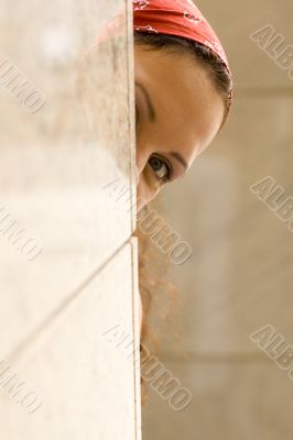 woman looking behind a wall