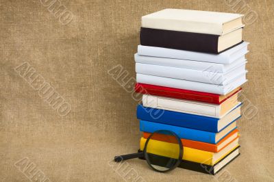 Big pile of books and magnifier glass