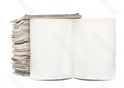 squared exercise book and magazines