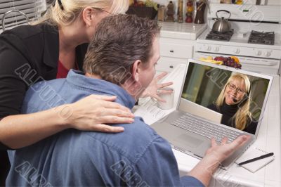 Couple In Kitchen Using Laptop - Customer Support