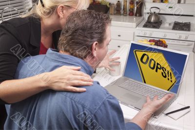 Couple In Kitchen Using Laptop - Oops! Sign