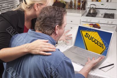 Couple In Kitchen Using Laptop - Success Sign