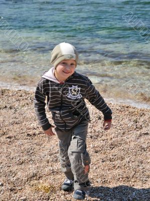 little blondy boy has a fun on the beach