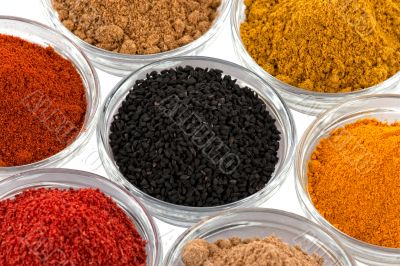 several indian spices in glass bowls