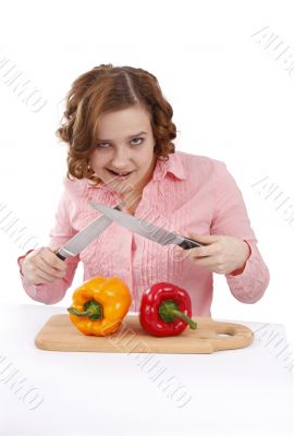 Housewife with sweet peppers and knifes.