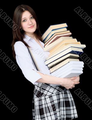 Girl with a pile of books in hands on black