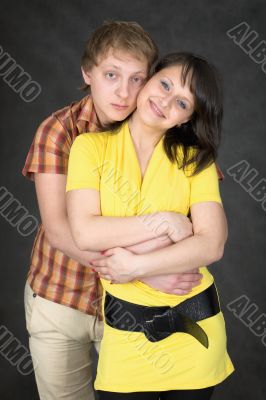 Couple embraces on a black background