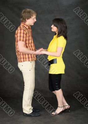 Young pair keeps for hands on a black
