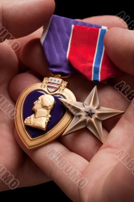 Man Holding Purple Heart and Bronze War Medals