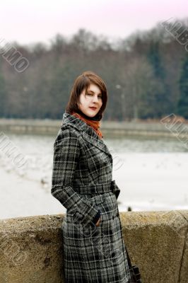 dark hair girl near river bank looking appear